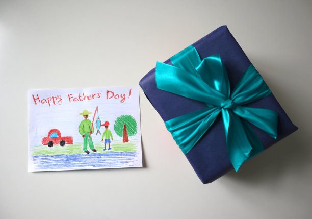 父亲节的卡片和礼物。白色背景。这张明信片是一个孩子画的。图片下载