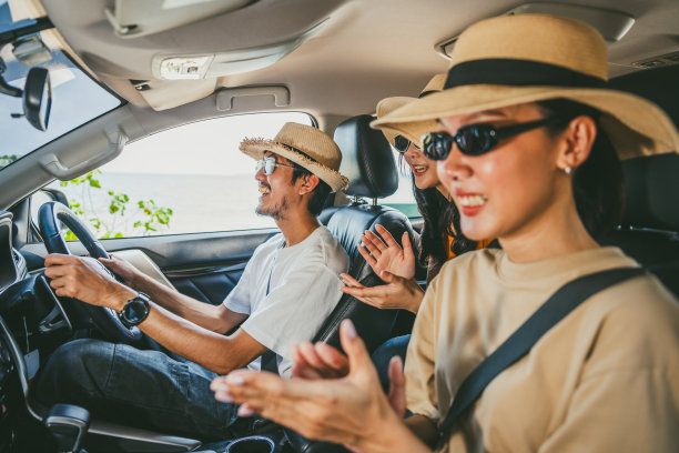 一群人，亚洲朋友，男人和女人在一个晴朗的日子里，在美丽的蓝天阳光下开车旅行。一路上他们都很开心。周末安全驾车度假图片下载