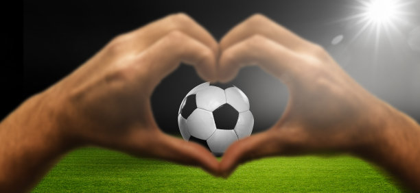 心的手与足球在体育场图片下载