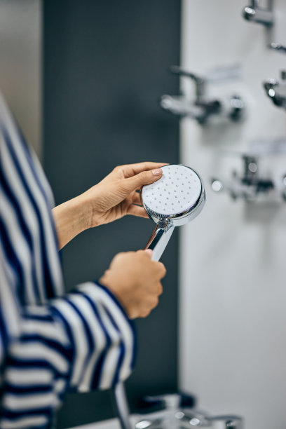 一位女顾客为浴室挑选淋浴喷头的特写照片。图片下载