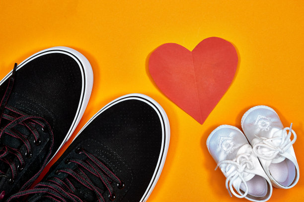 爸爸的靴子和宝宝的鞋有红纸心，父亲节的概念图片下载