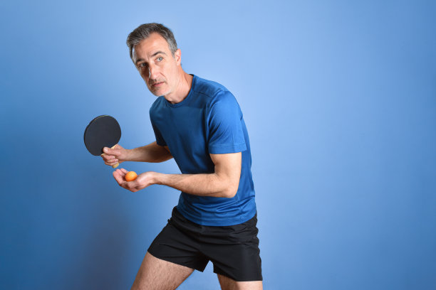 乒乓球运动员准备在蓝色背景上发球图片下载