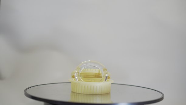 黄色盒子里的圆形水晶可以折射光线，使我们的照片看起来更好看。晶体在旋转的玻璃表面。图片下载