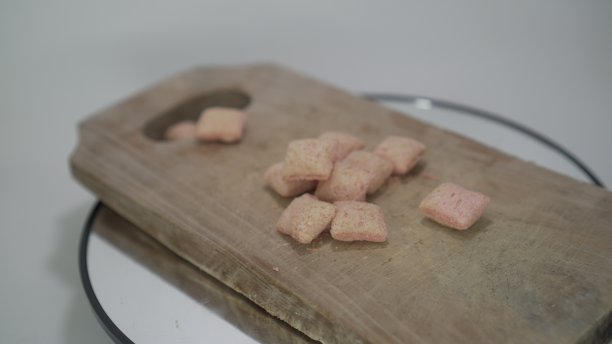 脆脆的蛋糕切成粉红色的方块，美味的草莓酱堆叠在旋转的木制砧板上。图片下载