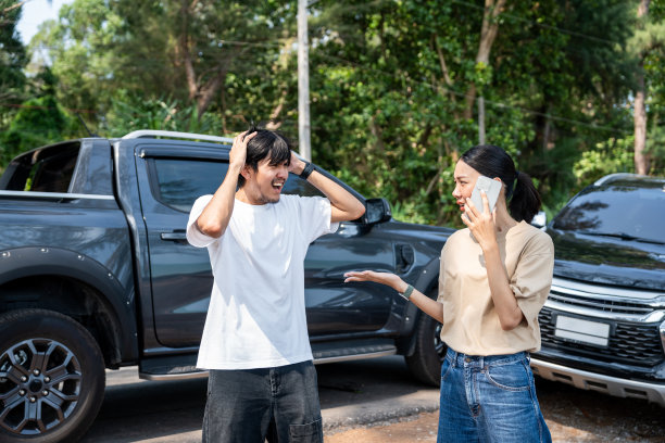 亚洲男女司机在交通碰撞事故后争吵，感到严重和压力。请致电紧急援助或保险索赔服务。车祸图片下载