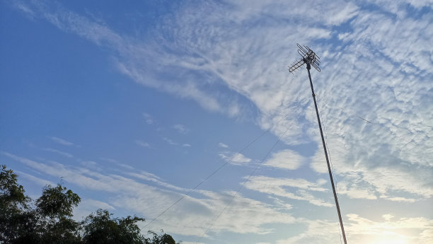 电视天线杆后面的美丽云彩。多云天空下的电视天线图片下载