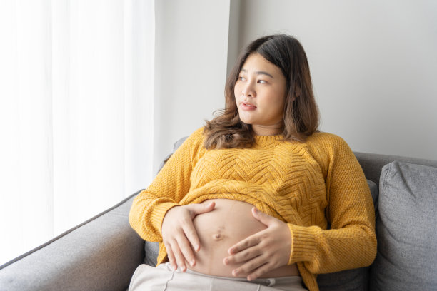 怀孕的亚洲妇女双手放在肚子上抚摸她的孩子，关心她的健康美丽快乐怀孕womanÂ温柔的心情怀孕照片图片下载