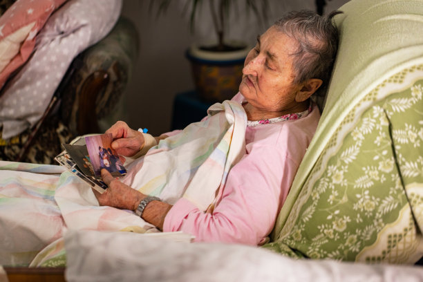 生病的老年妇女翻看家庭照片图片下载