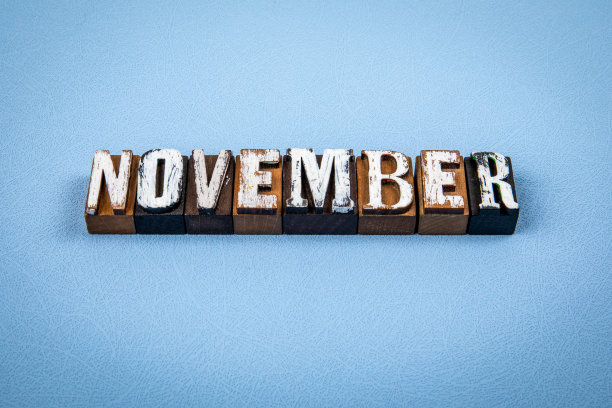 11月。蓝色纹理背景上的木制字母块图片下载