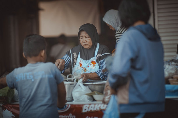 成熟的印尼女食品商贩正在为买家服务图片下载