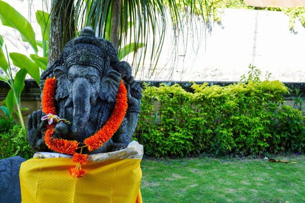 头戴黄色花环的甘尼萨神雕像，这是印度教巴厘岛宗教信仰的传统图片下载