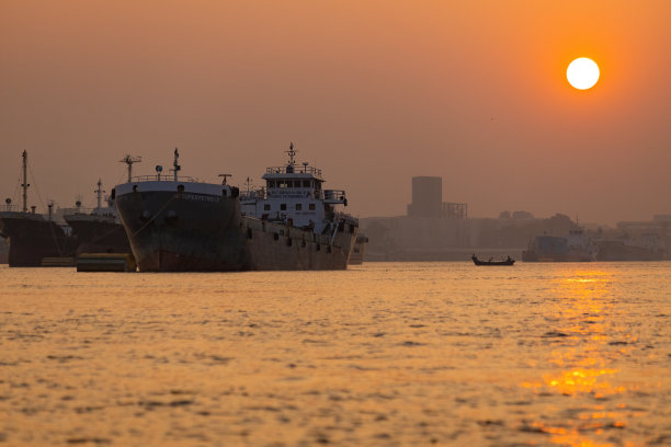 日落时分，吉大港的船只在水面上图片下载
