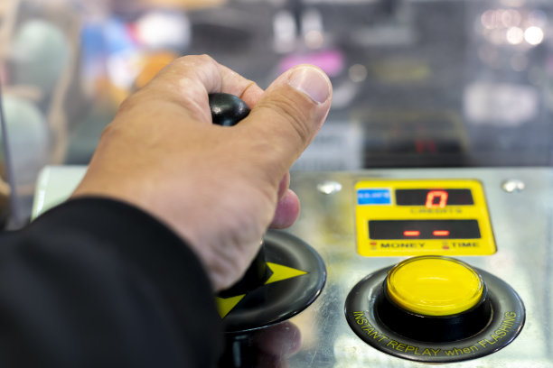 一个孩子操纵着街机的操纵杆，图片下载