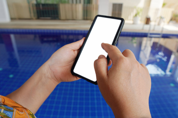 人们坐在家里的泳池边使用智能手机的画面，数字参与。图片下载