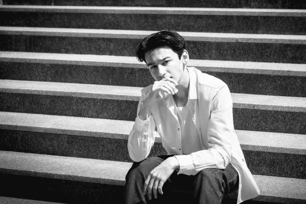 年轻人，十几岁的模特坐在城市的台阶上。休闲、时尚。BW颗粒照片图片下载