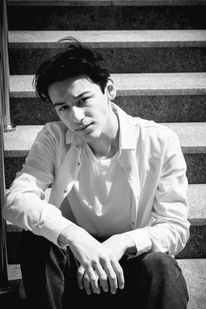 年轻人，十几岁的模特坐在城市的台阶上。休闲、时尚。BW颗粒照片图片下载