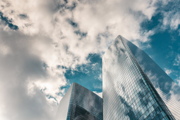 低角度视图的玻璃摩天大楼在纽约市与天空中的云-股票照片图片下载