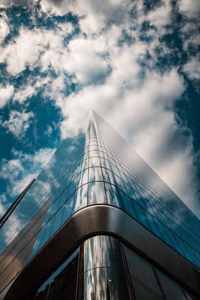 低角度视图的玻璃摩天大楼在纽约市与天空中的云-股票照片图片下载