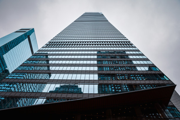 低角度视图的玻璃摩天大楼在纽约市与天空中的云-股票照片图片下载