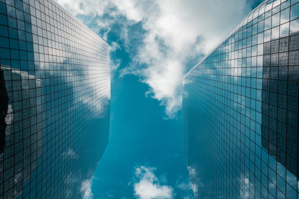 低角度视图的玻璃摩天大楼在纽约市与天空中的云-股票照片图片下载