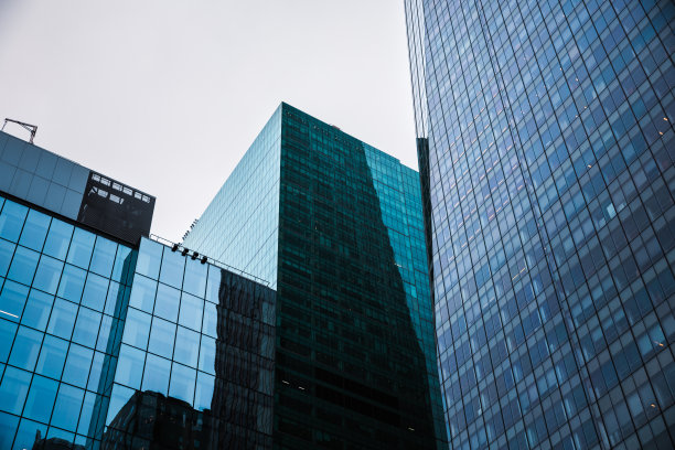 低角度视图的玻璃摩天大楼在纽约市与天空中的云-股票照片图片下载