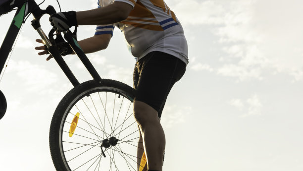 一个骑自行车的人在天空的背景下修理自行车图片下载