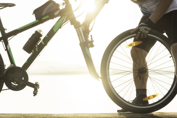 一个骑自行车的人在天空的背景下修理自行车图片下载