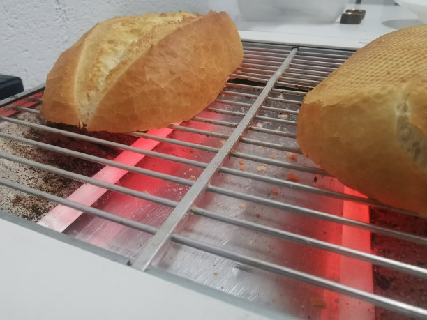 早餐面包切成两半的照片细节，放在火红的烤箱上烤图片下载