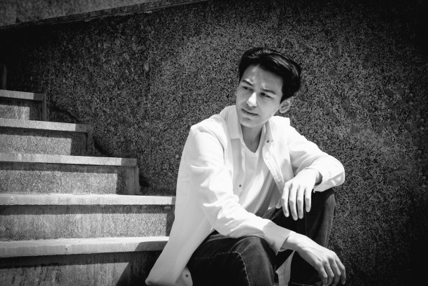 年轻人，十几岁的模特坐在城市的台阶上。休闲、时尚。BW颗粒照片图片下载