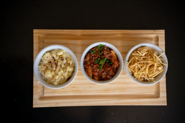 三碗食物、面包和肉放在砧板上的照片图片下载