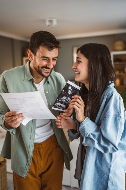 幸福的孕妇和她的丈夫一起看婴儿的超声波照片图片下载