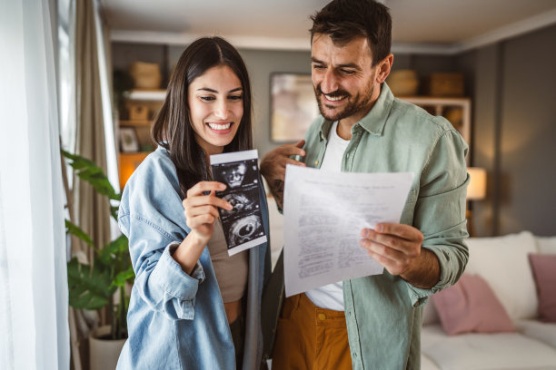 幸福的孕妇和她的丈夫一起看婴儿的超声波照片图片下载