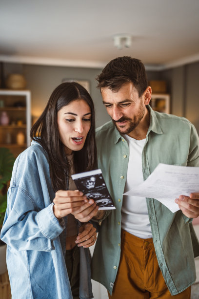 幸福的孕妇和她的丈夫一起看婴儿的超声波照片图片下载