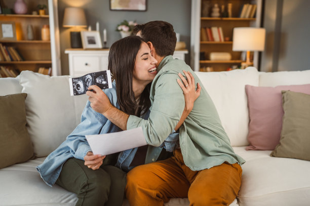 幸福的孕妇和她的丈夫一起看婴儿的超声波照片图片下载