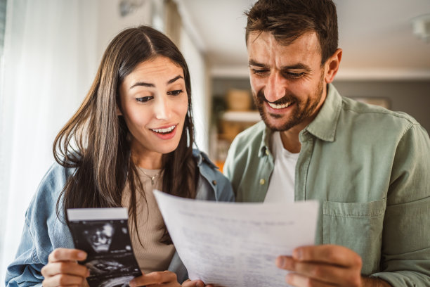 幸福的孕妇和她的丈夫一起看婴儿的超声波照片图片下载