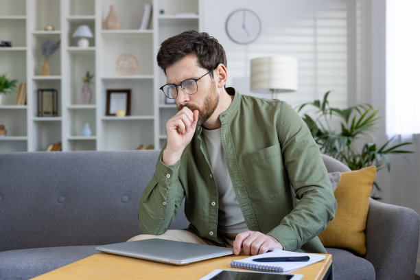 有思想的年轻人在家里用笔记本电脑工作，思考和计划图片下载