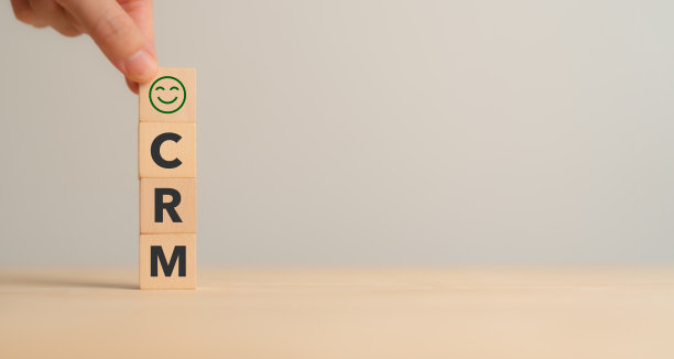 CRM，客户关系管理概念。客户满意度，保留策略。CRM或客户忠诚度计划横幅。木制立方体块与CRM符号在最小的背景。图片下载