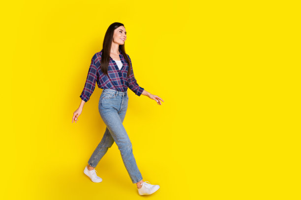 有魅力的年轻女子在黑色星期五穿着时尚的格纹衣服，黄色背景孤立的全尺寸照片图片下载