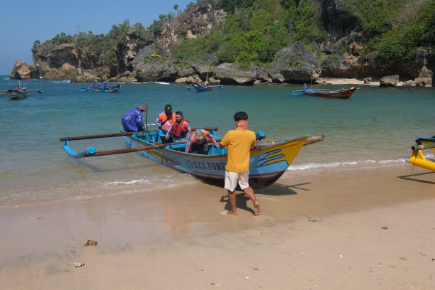 在Ngrenehan海滩上，一群渔民在公海上搜寻了一夜之后，将这艘船推向海滩。图片下载