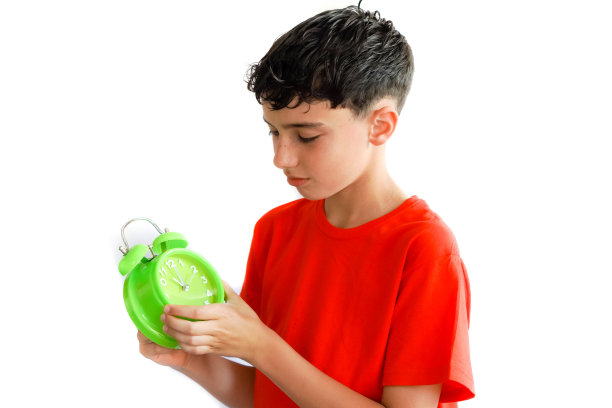 儿童，青春期前，白色背景，有雀斑，用一个手势或姿势设置闹钟或闹钟上的闹钟图片下载