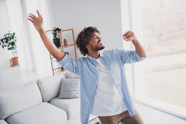照片凉爽的好心情的男人穿着格子衬衫呆在家里有乐趣唱歌麦克风在房子的公寓房间图片下载
