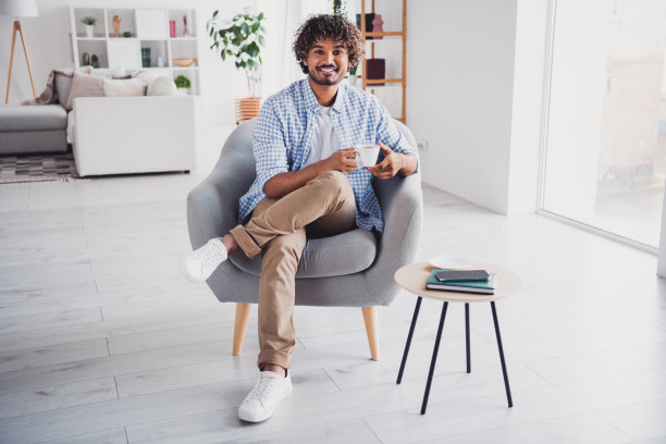 时髦的积极的男人穿着格子衬衫享受咖啡呆在家里的房子公寓房间里的照片图片下载