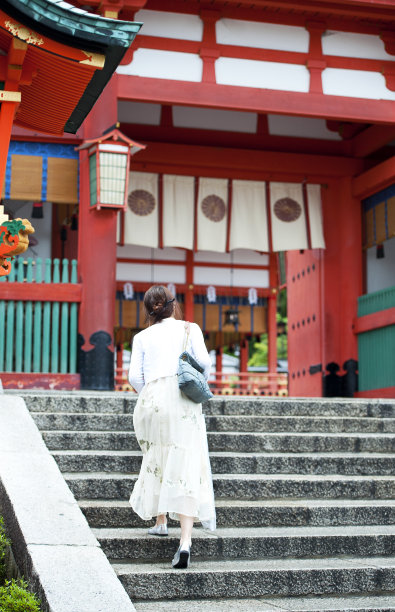 一名女子爬上日本大阪的富见稻成神社的台阶。图片下载
