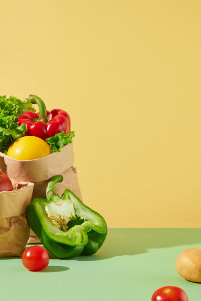 天然蔬菜广告创意照片，正面拍摄。绿色柜台左侧摆放着一袋蔬菜，背景为黄色。文本复制空间图片下载