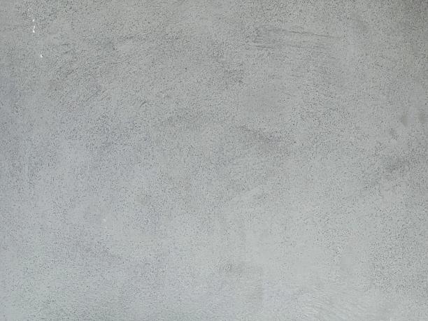 一名男子骑着滑板从水泥覆盖的斜坡上滑下的照片。图片下载