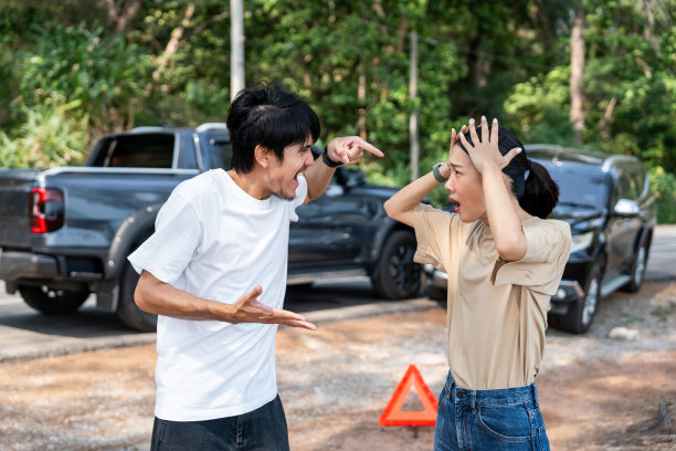 亚洲男女司机在交通碰撞事故后争吵，感到严重和压力。请致电紧急援助或保险索赔服务。车祸图片下载