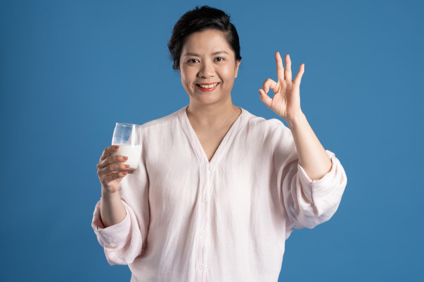 老亚洲妇女的肖像在蓝色背景上摆姿势图片下载