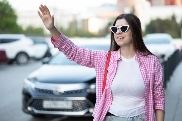 一名妇女在城市街道上叫出租车图片下载