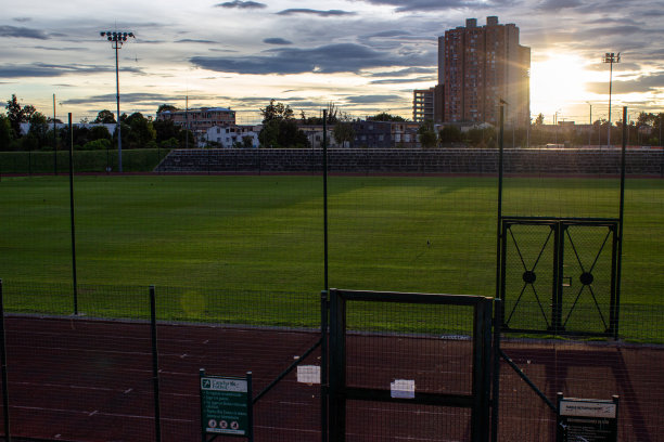 日落时田径跑道旁的足球场图片下载