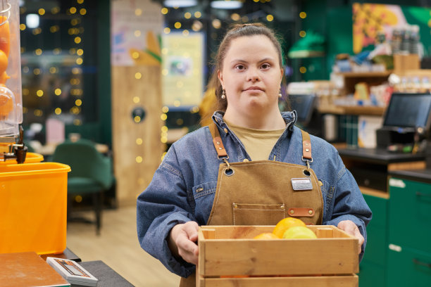 残疾女孩在超市的水果储藏箱里工作图片下载